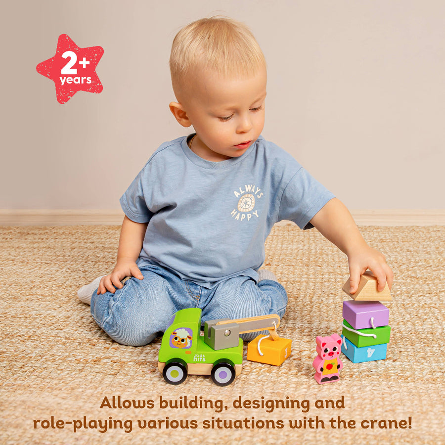 Child playing with toy crane and blocks on a carpeted floor