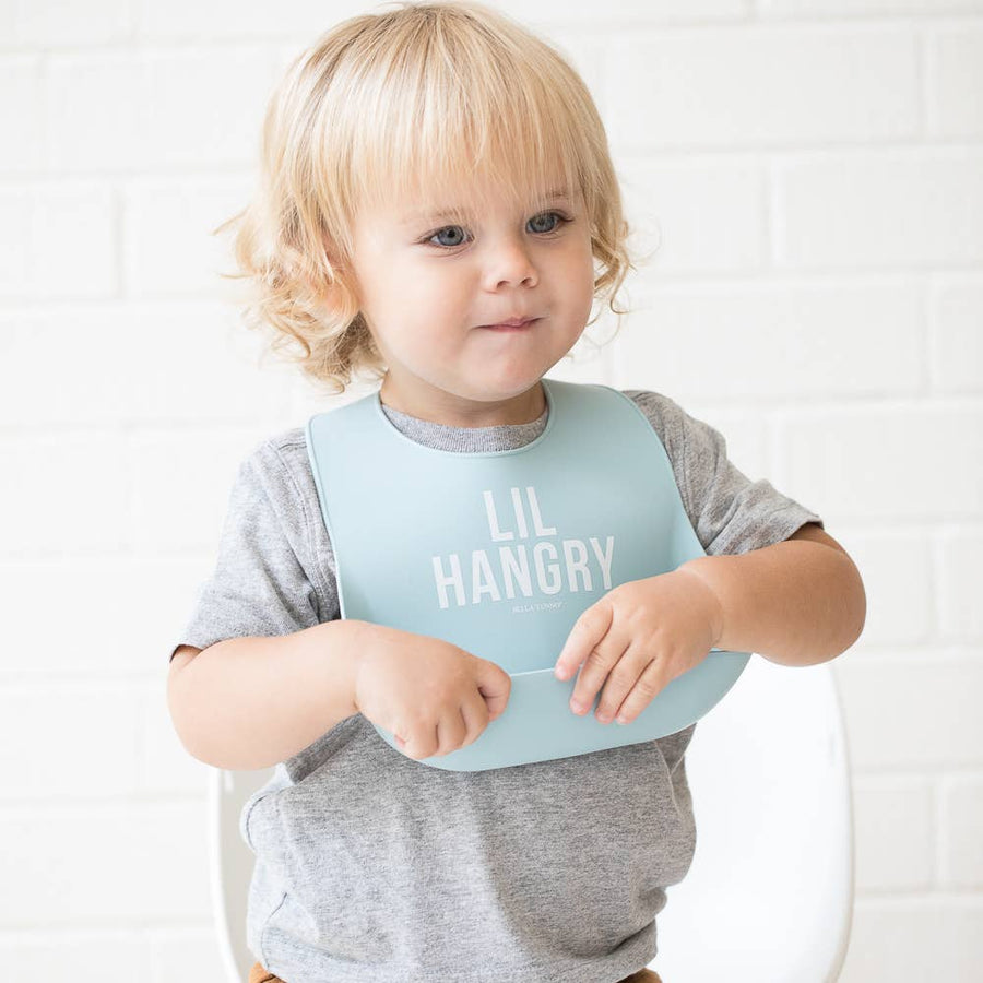 Child wearing a light blue bib with 'LIL HANGRY' text on a white background