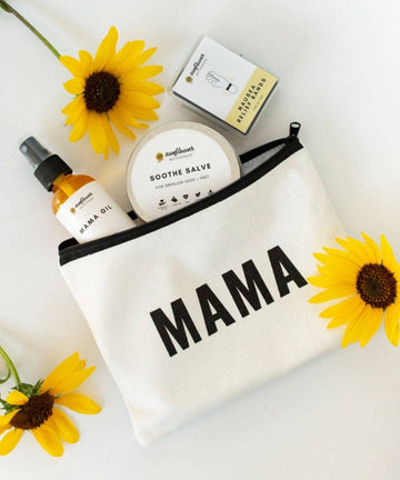 Image shows the unzipped Mama pouch with Mama Oil and Soothe Salve partially inside and Nausea relief bands next to it, laying on a white table with several yellow sunflowers