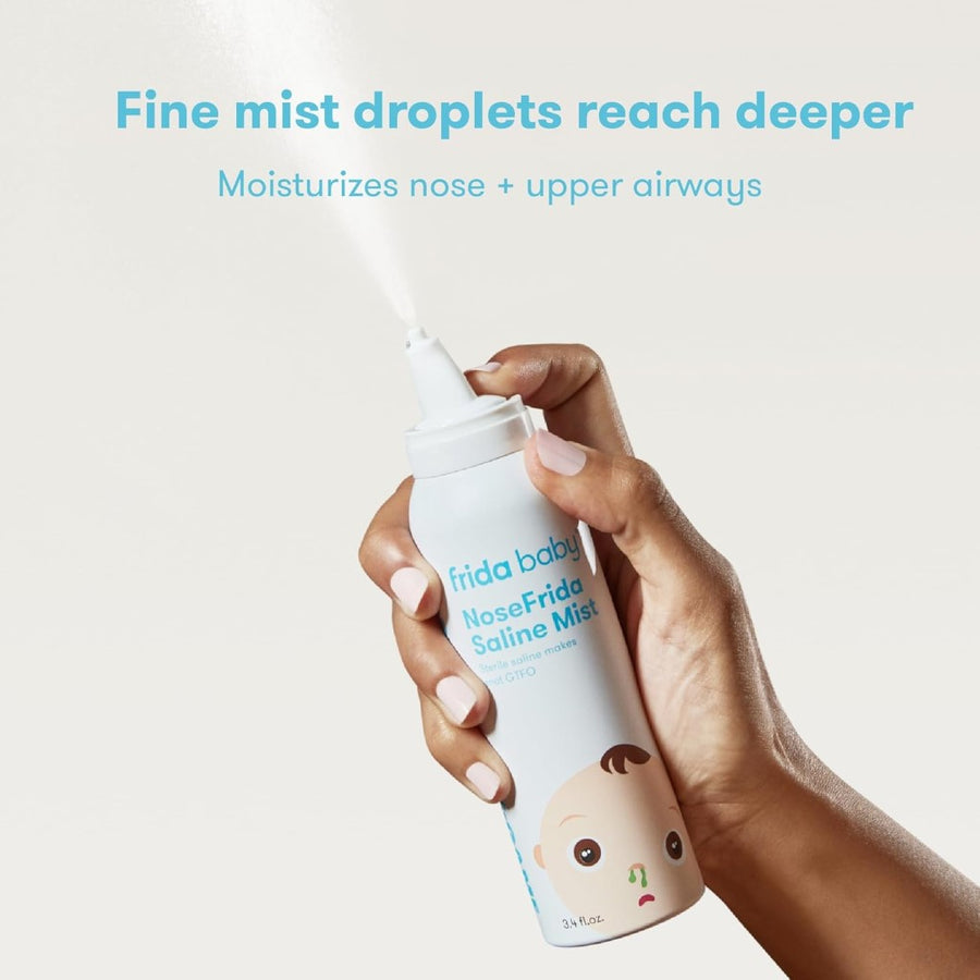 Image of a hand and forearm with a medium skin tone and manicured nails, holding the NoseFrida Saline Mist and pressing the button to spray it, against a cream background. Superimposed text reads, 