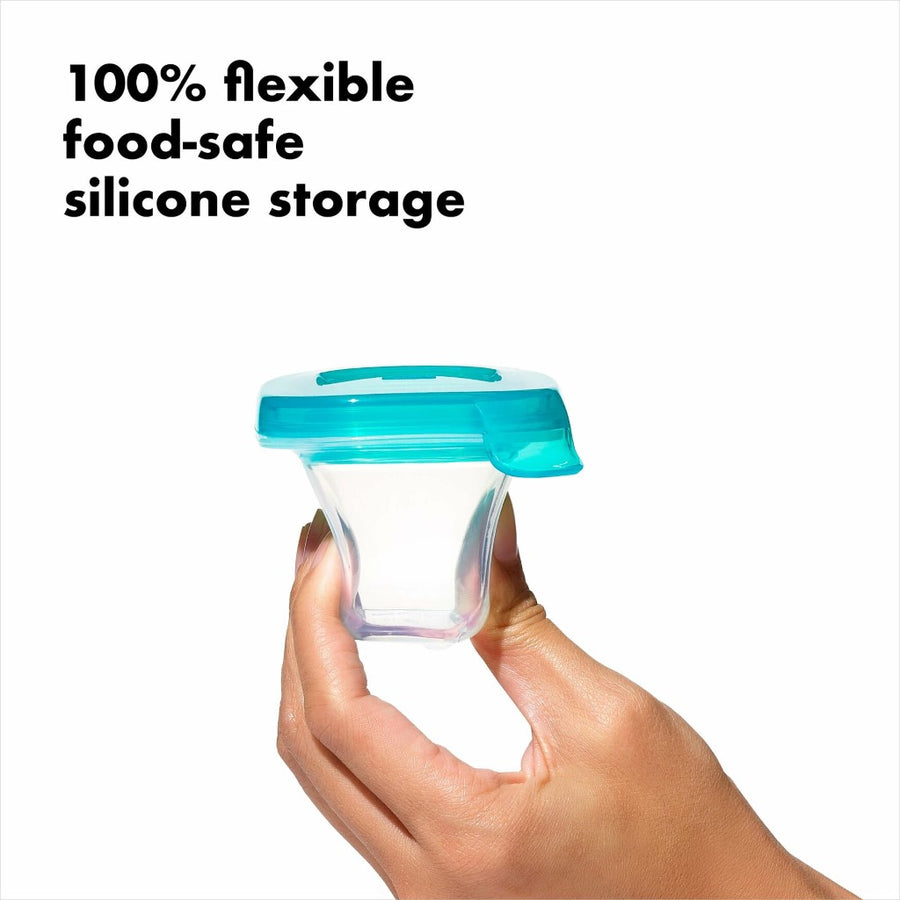 A light-skinned hand is squeezing an empty silicone baby block, with text that reads, 