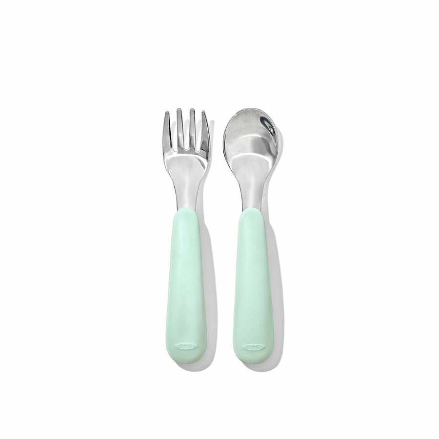 Baby fork and spoon with light green handles on a white background