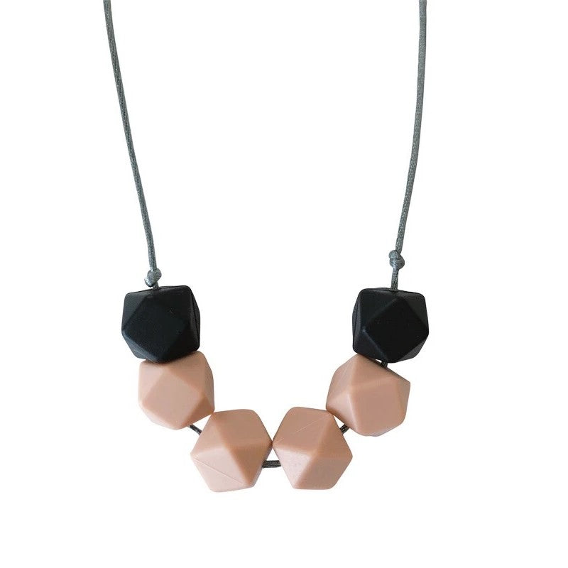 Picture of a teething necklace made of black and beige geometric silicone beads on a gray satin cord